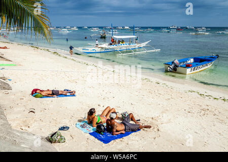 Junge Menschen beim Sonnenbaden auf Alona Beach, Bohol, Philippinen Stockfoto