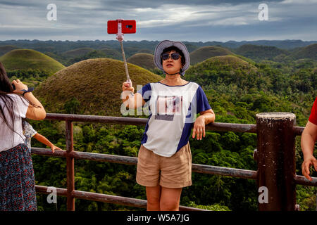 Eine asiatische Frau, eine selfie an der Chocolate Hills Aussichtsplattform, Carmen, Bohol, Philippinen Stockfoto