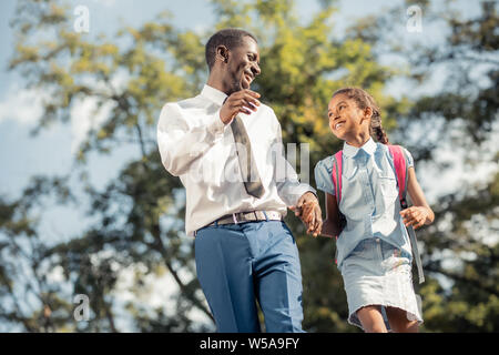 Freudige Vater und Tochter gehen Hand in Hand nach Klassen Stockfoto