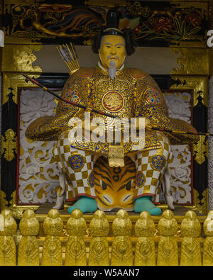 Statue von Samurai guard sitzen am Eingang Tor von Tosho-gu in Nikko in reiche goldene Rüstung mit Kunstwerken Details bedeckt, Japan, Oktober 2018 Stockfoto