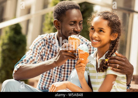 Freundliche langhaarige Mädchen hören zu ihrem Vater. Stockfoto