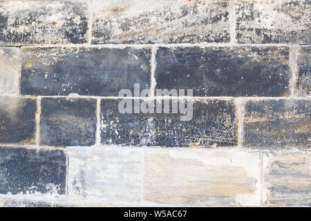Beige und Blak sandsteinmauer als Hintergrund Stockfoto