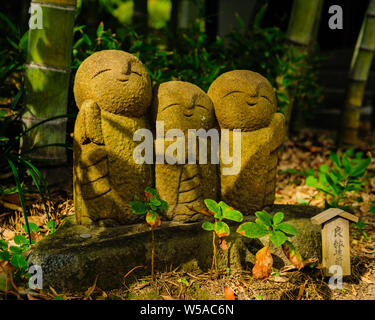 Kleine steinerne Statue eines kleinen betenden Mönch in einem komisch aussehende Gestalt mit reichen Details, Hase-dera Kamakura Japan 2018 Stockfoto