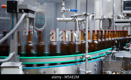 Bierflaschen Bewegungsunschärfe. Bier Flaschen auf dem Transportband. Flache Freiheitsgrad. Selektive konzentrieren. Stockfoto