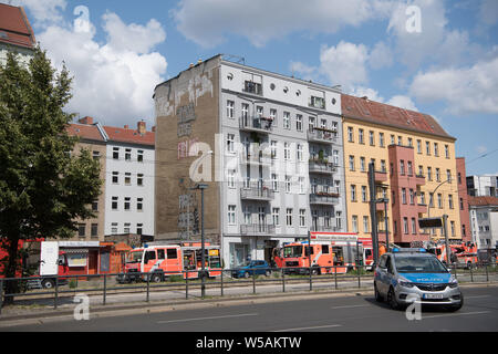 Berlin, Deutschland. 27. Juli, 2019. Feuerwehrmänner stehen auf dem Dach eines Mehrfamilienhauses in der Danziger Straße. Ein Feuer war in einem Apartment im Dachgeschoss des Gebäudes ausgebrochen. Quelle: Jörg Carstensen/dpa/Alamy leben Nachrichten Stockfoto