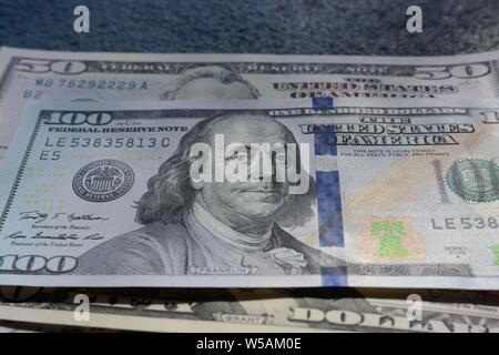 Nahaufnahme von hundertfünfzig Dollar Scheinen auf einem Grauer Hintergrund Stockfoto