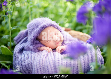 Beginn des Lebens und glücklich Fairy Magic Kindheit Konzept. 17 Tage alten Lächelnd neugeborenes Baby schläft auf dem Bauch im Warenkorb auf die Natur in der g Stockfoto