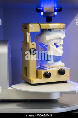 Vertikale Aufnahme einer Maschine mit modellierten Kiefer und Zähnen Und blaues Licht im Hintergrund Stockfoto