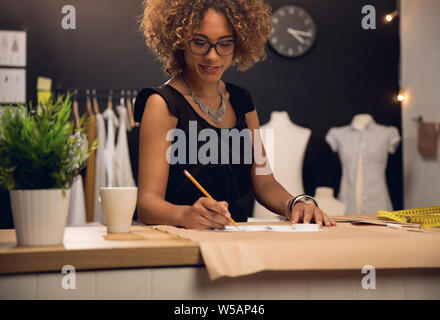 Eine junge Modedesignerin arbeitet an ihrem atelier Stockfoto