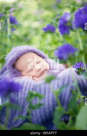 Beginn des Lebens und glücklich Fairy Magic Kindheit Konzept. 17 Tage alten Lächelnd neugeborenes Baby schläft auf dem Bauch im Warenkorb auf die Natur in der g Stockfoto