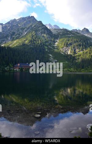 Die schöne Popradske Pleso mit dem Berg Hotel Popradske pleso, umgeben von den Bergen der Hohen Tatra, in der Abendsonne. Die Landschaft ist wider Stockfoto