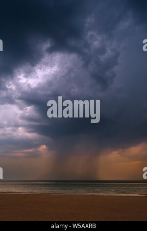 Gewitter, dunkle Regenwolken und Wolkenbruch/Sprühflutanlage über das Meer während der Hitzewelle/Hitzewelle im Sommer Stockfoto