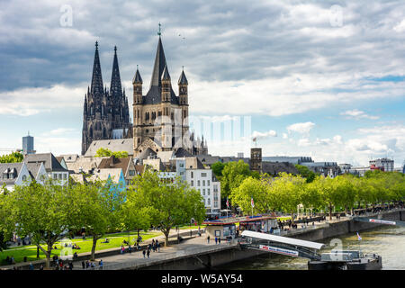 Köln, Deutschland - 12. Mai: Touristen am Rhein in Köln, Deutschland, am 12. Mai 2019. Blick auf den Kölner Dom und große Sain Martin Kirche. Stockfoto