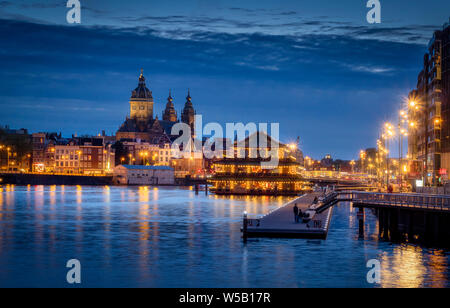 Oosterdok Kai bei Nacht, Sint Nicolaaskerk, St. Nicholas Kirche und China Restaurant Sea Palace, Amsterdam, Nordholland, Nordholland, Niederlande Stockfoto