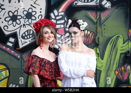 Kiew, Ukraine, Santa Muerte Karneval, 20.07.2019. Dia de los Muertos, Tag der Toten. Halloween. zwei Frauen mit Furcht erregenden Masken. Frauen tragen in Rot sind Stockfoto