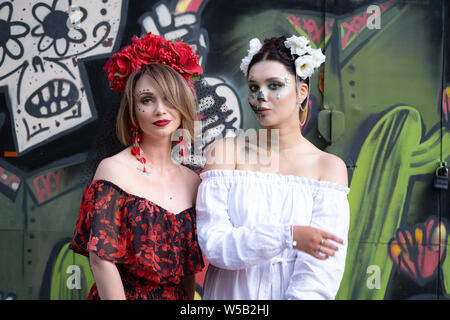 Kiew, Ukraine, Santa Muerte Karneval, 20.07.2019. Dia de los Muertos, Tag der Toten. Halloween. zwei Frauen mit Furcht erregenden Masken. Frauen tragen in Rot sind Stockfoto