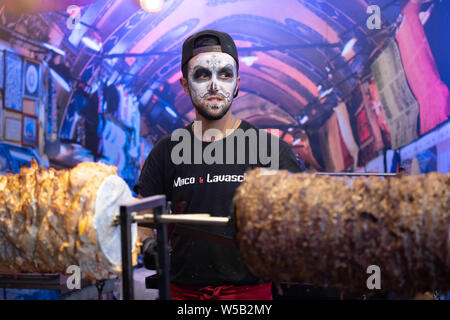 Kiew, Ukraine, Santa Muerte Karneval, 20.07.2019. Dia de los Muertos, Tag der Toten. Halloween. shawarma Verkäufer mit Skelett Make-up im Food Court Stockfoto