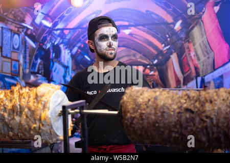 Kiew, Ukraine, Santa Muerte Karneval, 20.07.2019. Dia de los Muertos, Tag der Toten. Halloween. shawarma Verkäufer mit Skelett Make-up im Food Court Stockfoto