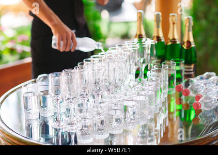 Der Kellner gießt Champagner auf dem Buffet. Stockfoto