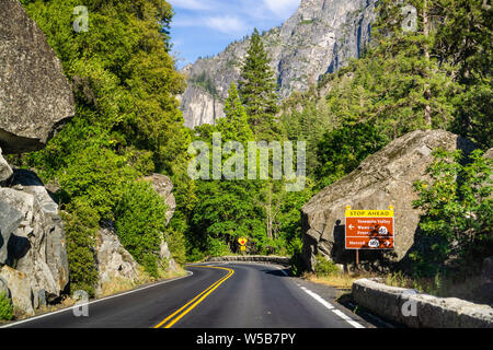 Schild auf der Autobahn 120 mit Stop vor Warnung und Richtungen gebucht; Yosemite National Park, in den Bergen der Sierra Nevada, Kalifornien Stockfoto