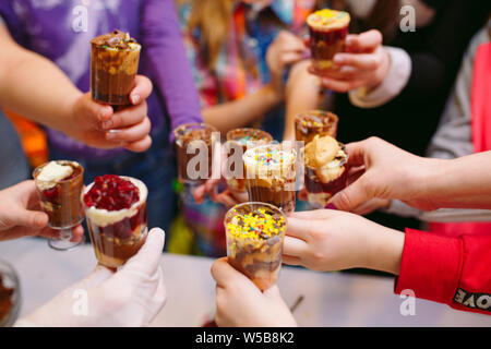 Kid's Party. Kinder holding Cupcakes in die Gläser. Stockfoto