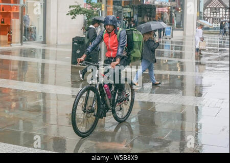 Manchester, Großbritannien. 27. Juli, 2019. Ein Mann fährt mit dem Fahrrad unter starkem Regen in Manchester. Credit: Yiannis Alexopoulos/SOPA Images/ZUMA Draht/Alamy leben Nachrichten Stockfoto