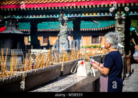 Frau zu beten und Räucherstäbchen an Sik Sik Yuen Wong Tai Sin Tempel. Hongkong Stockfoto