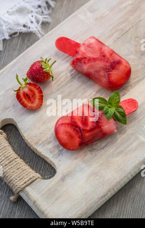 Hausgemachte Obst Popsicle Stick. Leckere hausgemachte Erdbeere Popsicle Stick auf hellen Hintergrund Stockfoto