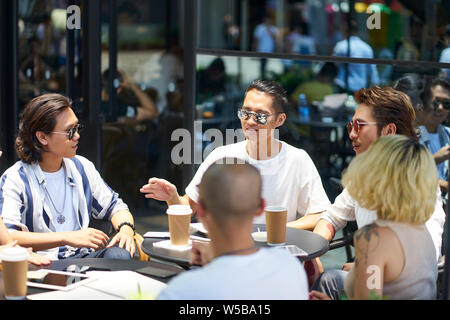 Jungen asiatischen Menschen, Mann und Frau entspannende Chatten in outdoor Coffee Shop Stockfoto