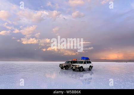 Zwei Geländewagen stehen auf dem Salzsee von Uyunu - Altiplano, Südamerika. Foto nicht Lärm oder Staub. Es Stücke von Salz. Stockfoto