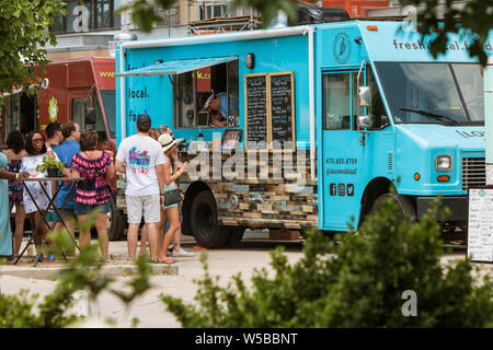 Die Menschen warten in der Linie und die aus einem Lebensmittel Lkw am Alten vierten Bezirk Essen Truck Festival geparkt am 19. Mai 2018 in Atlanta, GA. Stockfoto