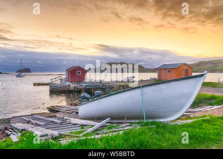 Boote und Schuppen in Küsten Fischerdorf bei Sonnenuntergang in Neufundland, Kanada Stockfoto