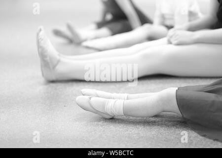 Mädchen mit einer Choreographin auf dem Boden in einem Tanz Klasse sitzen Stockfoto