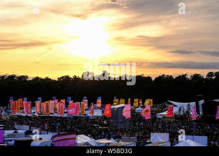 Malmesbury, Wiltshire, UK. 26. Juli 2019. Die Sonne über dem WOMAD-Festival (Welt der Musik, Kunst und Tanz) am Samstag, 27. Juli 2019 in Charlton Park, Malmesbury. An einem Tag des durchwachsenes Wetter, die Wolken lassen die Sonne durch, wie es setzt. Bild von Julie Edwards Stockfoto