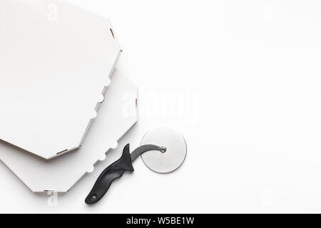 Leere Kartons und Pizza Cutter auf weißem Hintergrund Stockfoto