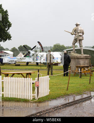 Krieg und Frieden Revival 2019, Paddock Wood Hop Farm. Zwei Männer, der eine Statue des Zweiten Weltkrieges Soldat. Stockfoto