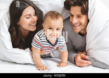 Happy Family spielen Versteck unter der Decke im Bett Stockfoto