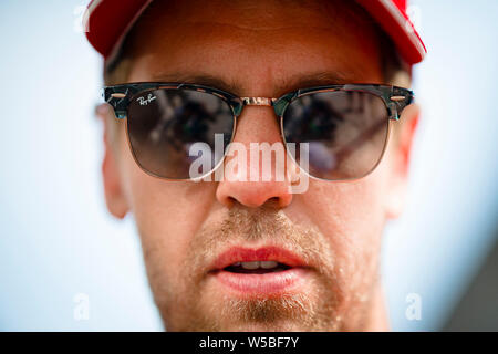 Scuderia Ferrari der Deutschen Fahrer Sebastian Vettel kommt für die Fahrer treffen während der Deutschen F1 Grand Prix. Stockfoto