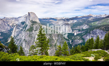 Blick auf den Half Dome; Vernal Fall, Nevada Fall und Freiheit Kuppel sichtbar auf der rechten Seite, die schneebedeckten Berge im Hintergrund; Yosemite National Par Stockfoto