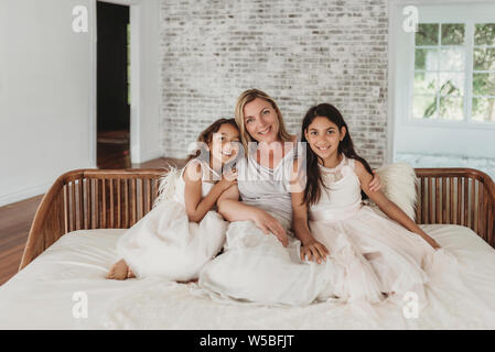 Mutter und Töchter sitzen auf der Couch in natürlichen - Light Studio. Stockfoto