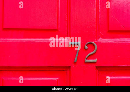 Haus Nummer 72 auf einem hellen Rot oder Rosa Holz- Vordertür Stockfoto