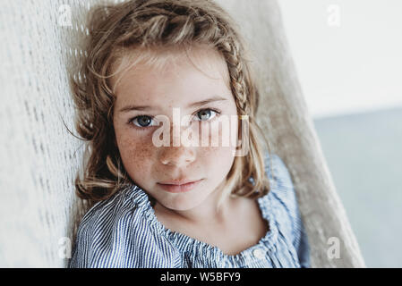 Porträt von Ernst schulpflichtigen Mädchen mit Zopf in ihrem Haar Stockfoto