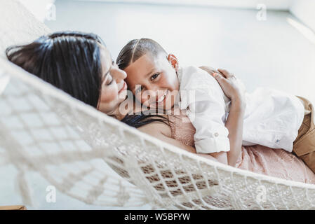 Mutter und Sohn Kuscheln bei der Verlegung in der Hängematte im Studio Stockfoto