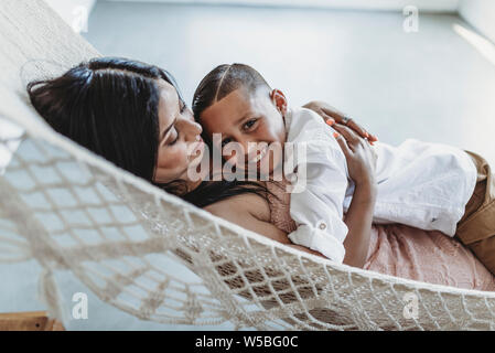 Mutter und Sohn Kuscheln bei der Verlegung in der Hängematte im Studio Stockfoto