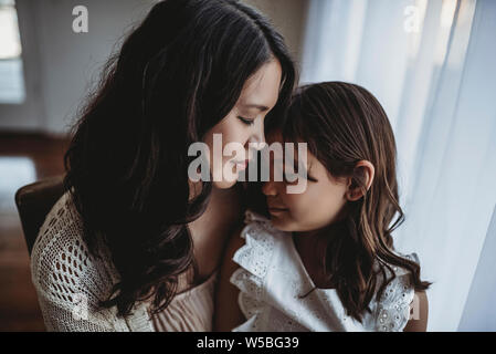 Nahaufnahme der Mutter und Tochter auf der Stirn berühren Stockfoto