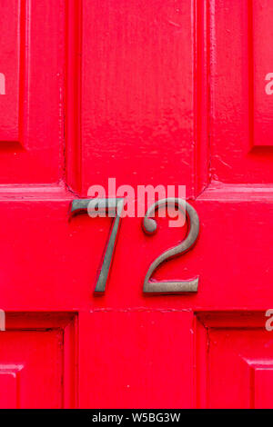 Haus Nummer 72 auf einem hellen Rot oder Rosa Holz- Vordertür Stockfoto