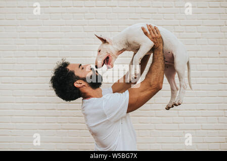 Bärtiger Mann mit einem weißen Bullterrier in Gewicht und in Hi suchen Stockfoto
