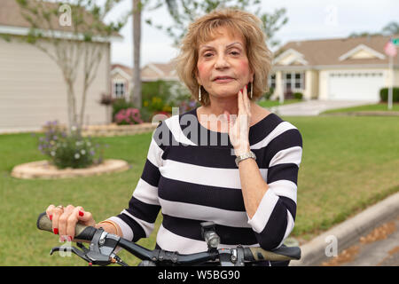 Reife Frau in den 70er Jahren einen Tag draußen genießen auf ihr Fahrrad. Stockfoto
