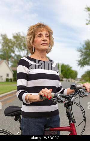 Reife Frau in den 70er Jahren einen Tag draußen genießen auf ihr Fahrrad. Stockfoto
