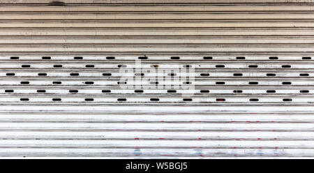 Alte Metall Rollladen weiße Farbe verblasst voller Hintergrund Textur. Garage oder Store Eingang Vorderansicht Stockfoto